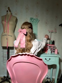 a girl sitting in a pink chair