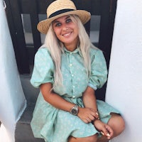 a blonde woman wearing a green dress and a straw hat